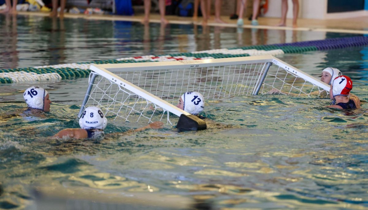 Attempting to fix the goal, varsity water polo girls swim in to help the goalie. Despite this, varsity girls played well in the tournament. “First home tournament was really great! Everyone was so pumped and motivated,” Kai Harrington said, a sophomore varsity water polo player.