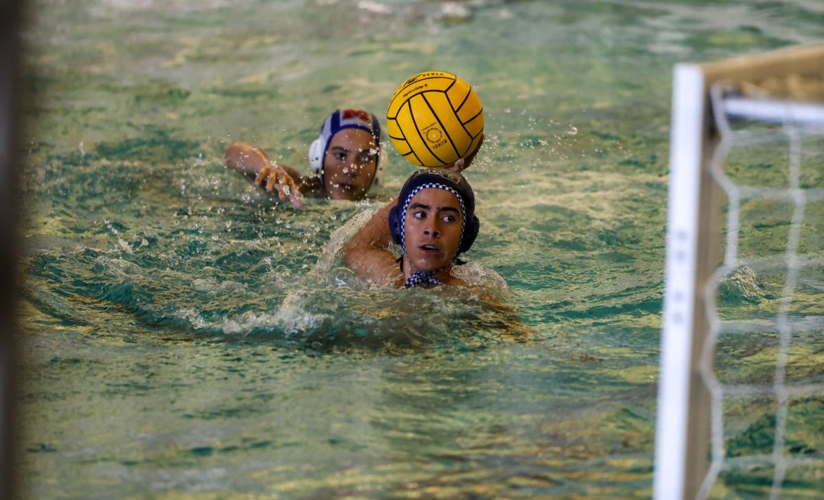 Ball in the air, Diego Perez-Mora, a sophomore varsity water polo player gets ready to shoot a goal. Water Polo boys shot fifteen goals against Midway, winning 15-3. This was one of their five games in their first home tournament, winning four out of five of their games.