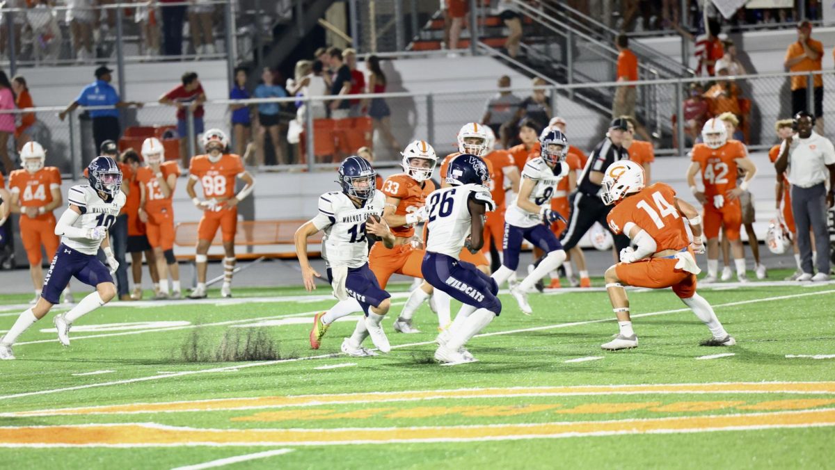 Arm around the ball, quarterback No. 12 junior Braden Butler sprints past Celinas defensive players. Butler scored a second touchdown, ending the first quarter 13-7 with Walnut Grove winning. Butler finished this game with 137 passing yards and four passing touchdowns. 