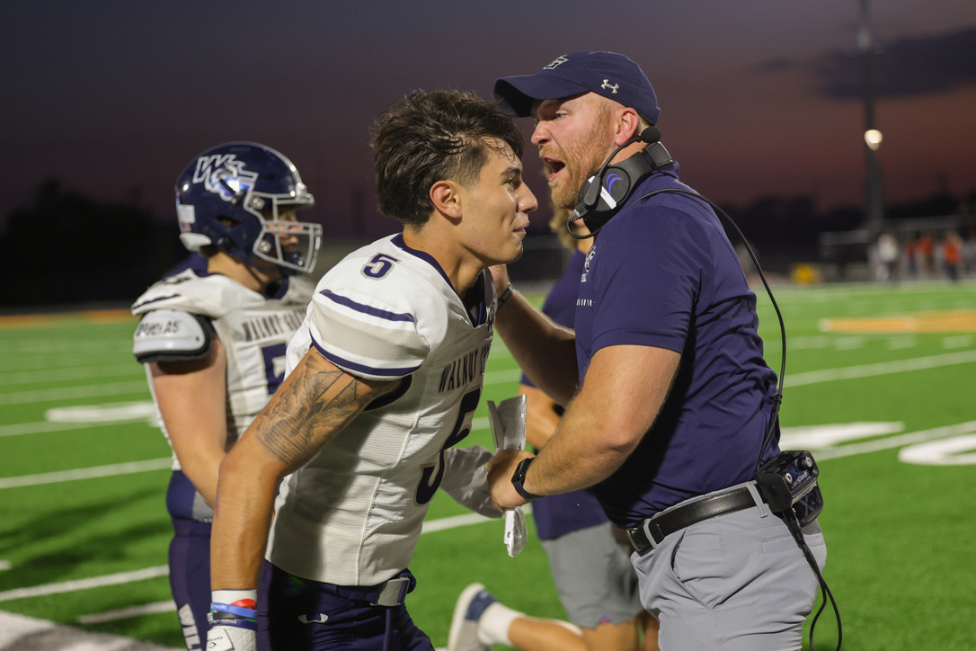 In celebration of a successful touchdown, varsity football coach Tyrel Lenard yells into No. 5 senior Frankie Masottos ear, We did it. No. 12 junior Braden Butler scored the second touchdown of the half. Varsity leads the game against Celina 13-7. 