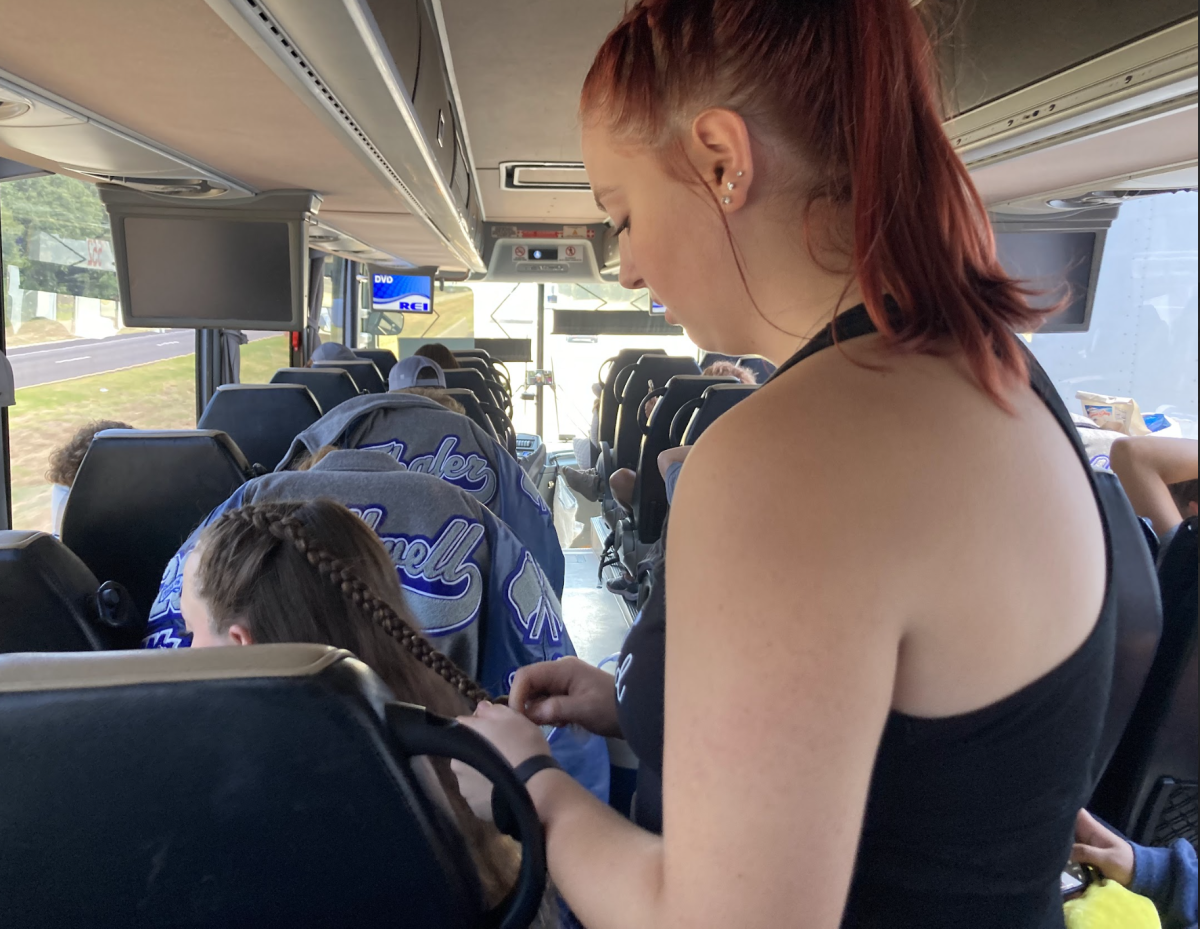 Sophomore Aly Fallwell braiding sophomore Annika Spencers hair. “You know, I was standing there, and Ive done hair for not too long, but I’ve been doing it for the past two years and I enjoy it a lot, so I was like, “Hey! We should all match”. So, I started peoples hair on the bus. I loved it. It was a lot of good bonding time with my team, said Fallwell.