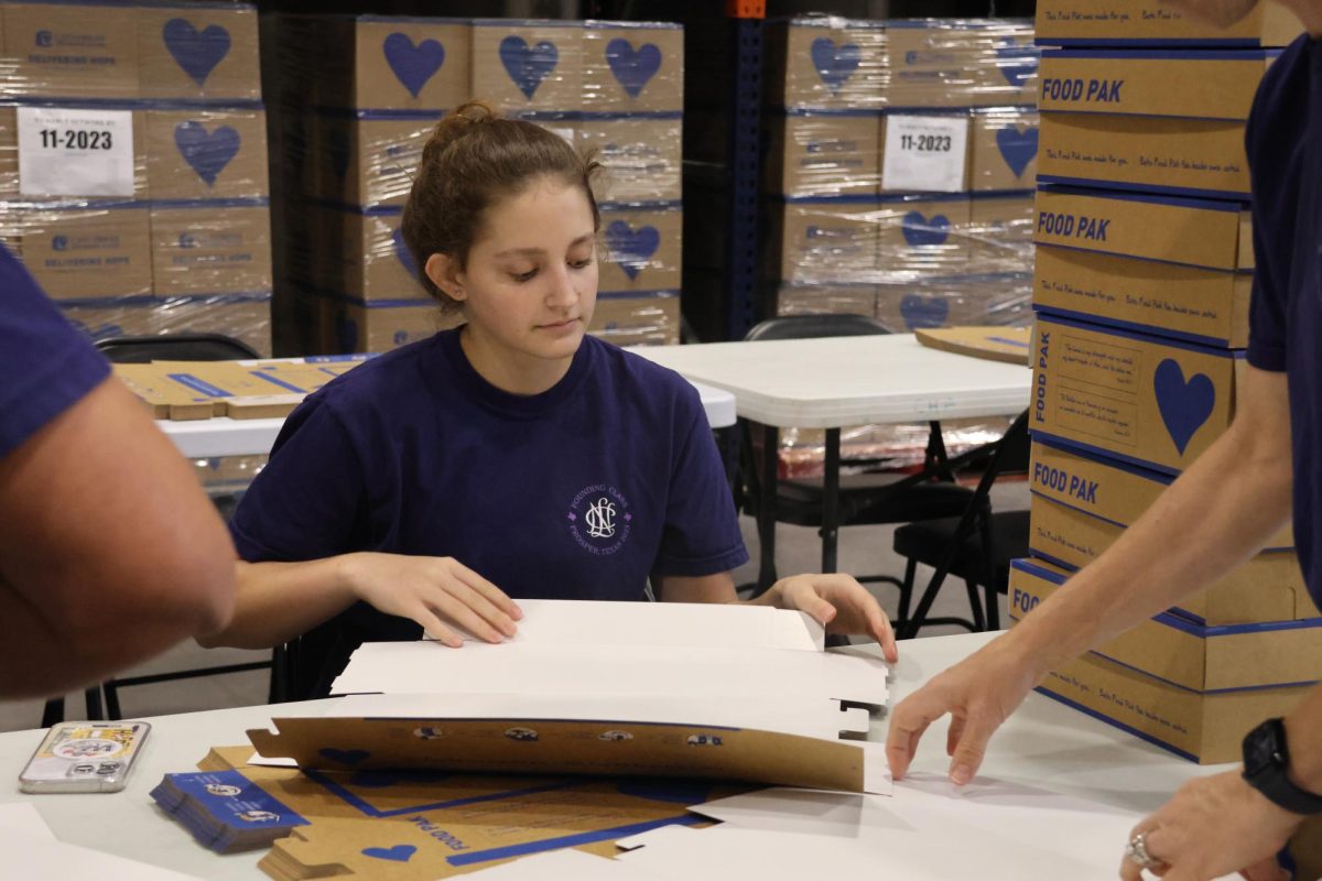 Focused in the moment, sophomore Maddie Wooten carefully folds each Food Pak at the Childrens Hunger Foundation in Frisco, Texas. 