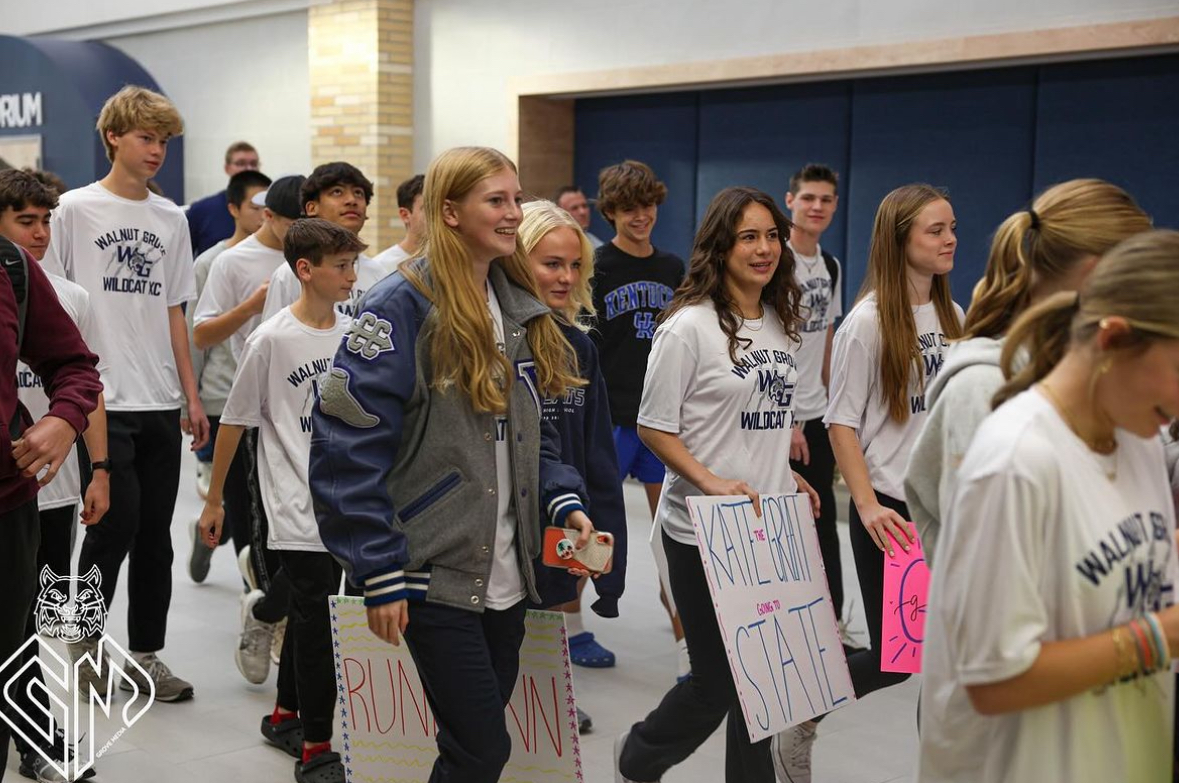 Ready to walk the send-off, Kate Wichar, among members of the cross country team, leads down the main hall as students cheer. Wichar sets to compete for the State title in cross country on Nov. 3. 