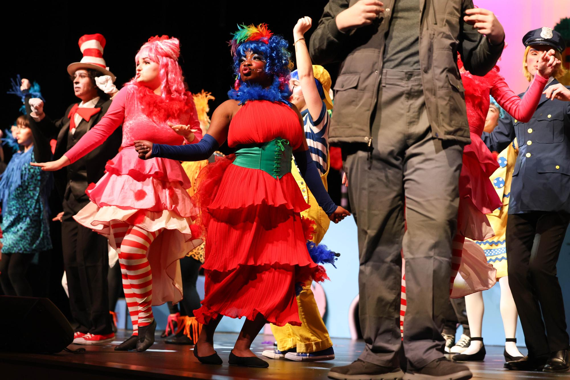 To the beat, Elizabeth Fasesimi sings and dances with the cast. Fasesimi, dressed in a bright red dress with a rainbow hair and tail, plays Mayzie the bird in Seussical the Musical. Mayzie sings many songs troughout the Musical, such as How Lucky You Are and the closing song Green Eggs and Ham.