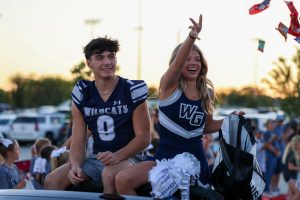 Candy thrown in the air, senior Maggie Willams gives candy to the crowd. Maggie and Leon Kransqni are running  for Homecoming senior court.  All court nominees rode in the parade. 