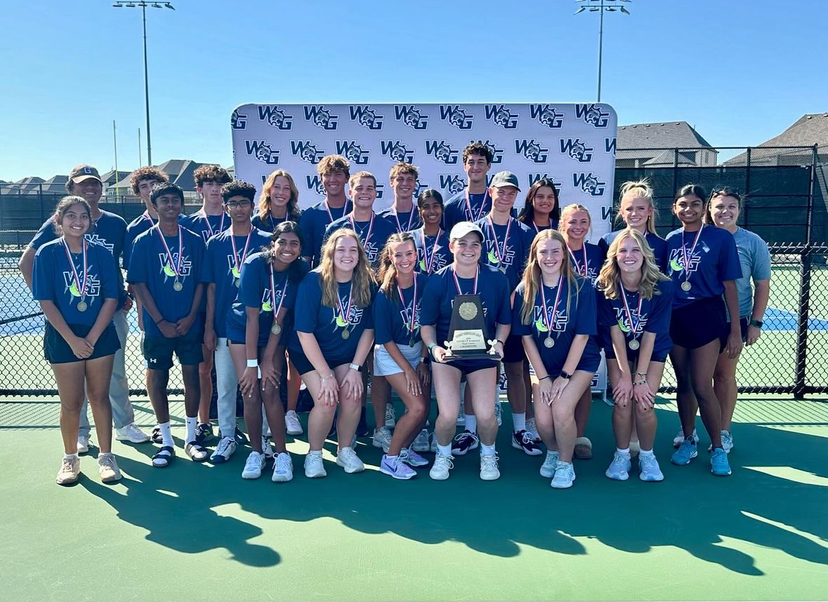 Smiles on their faces, the varsity tennis team celebrates their district win. They were each given individual medals along with a district trophy.