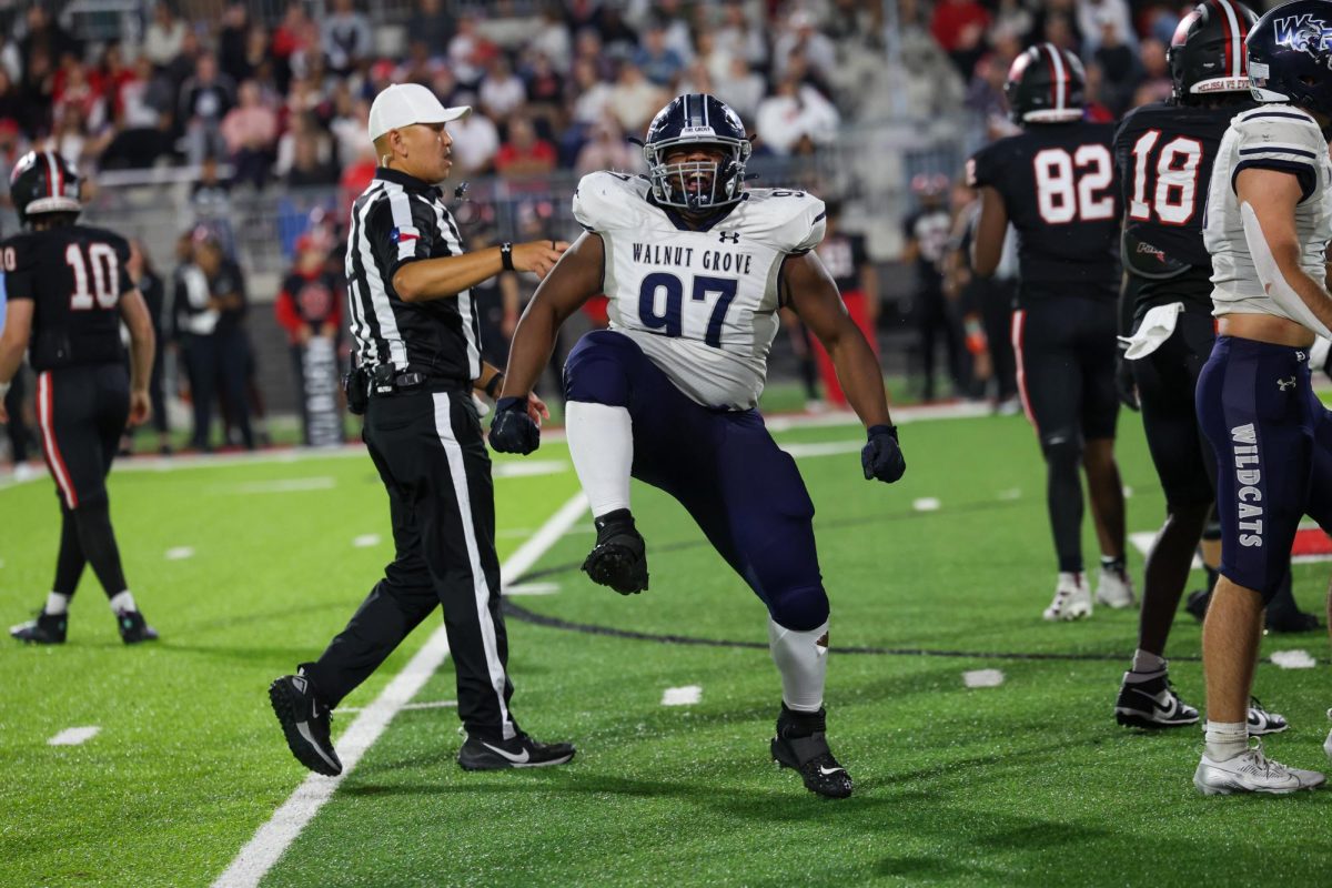 Foot raised high, No. 97 freshman Kristopher Williams celebrates after tackling opposing player. Willams finished the game with 2 tackles.