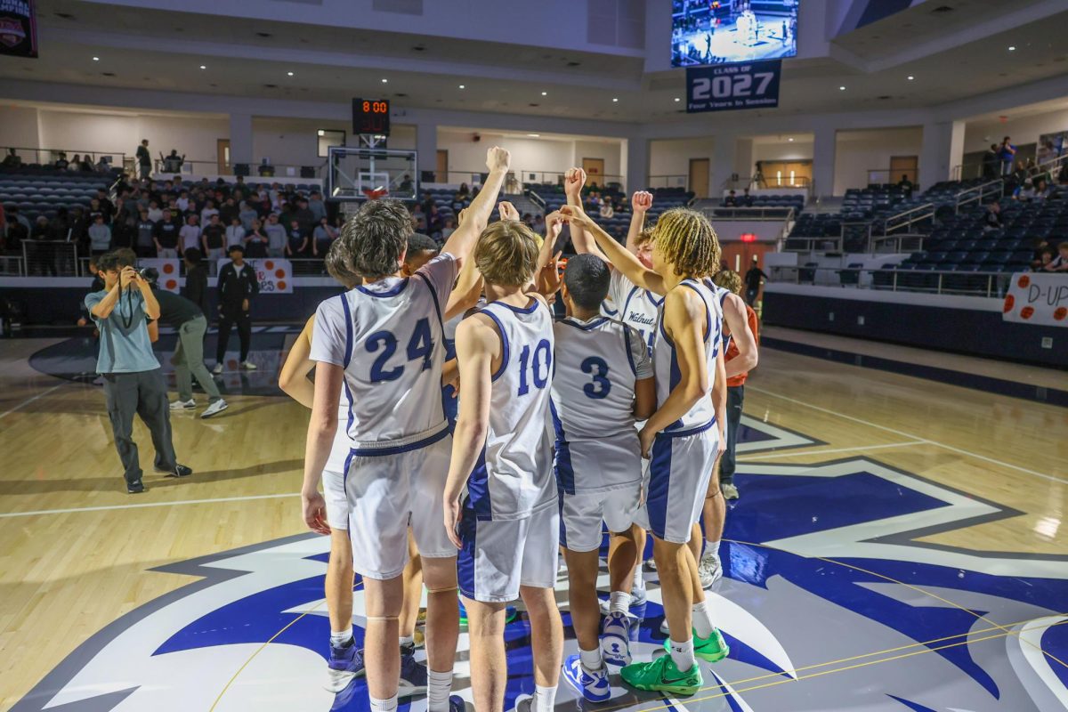 Hand raised, the team meets in the middle of the court after player introductions. 