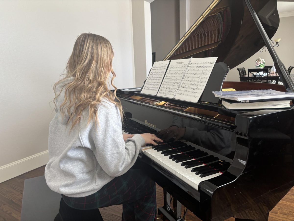 Brielle Brandvold is sitting in front of her piano at home. She is getting ready to practice a song on some sheet music. 
