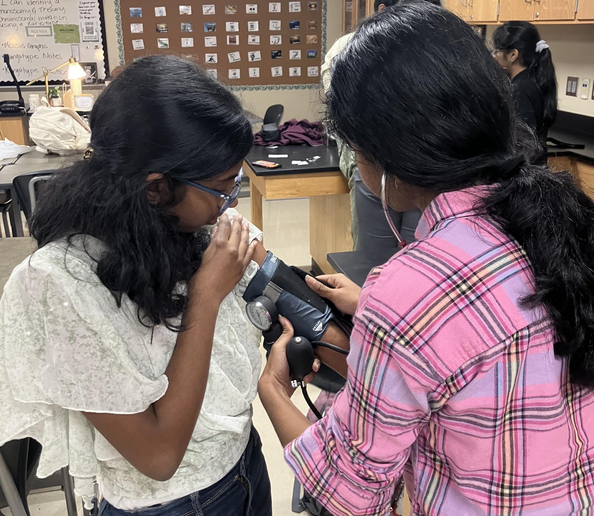 Two participants at a vital signs workshop at Prosper High School that was conducted by students in CNA. They covered how to take temperature, find a pulse, measure blood pressure and respiratory rate.
