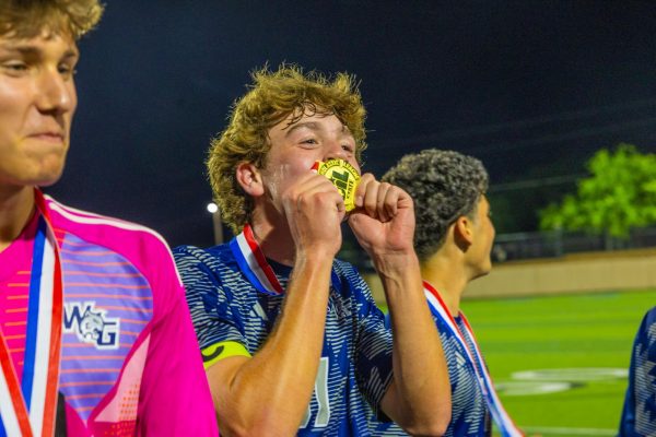 Mouth to medal, senior Carter Causey kisses his gold medal after winning state. The result of the state game was 3-2 after playing in double overtime.