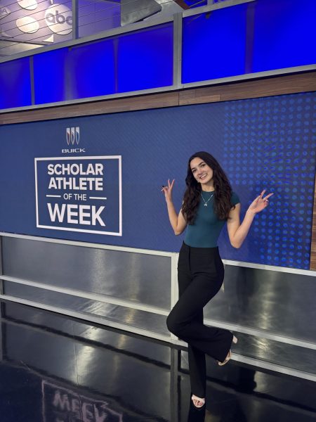 Hands in a peace sign, senior Kallie Huck poses for the camera. This picture was taken on the first media day from the WFAA student athlete scholar of the week interview. 