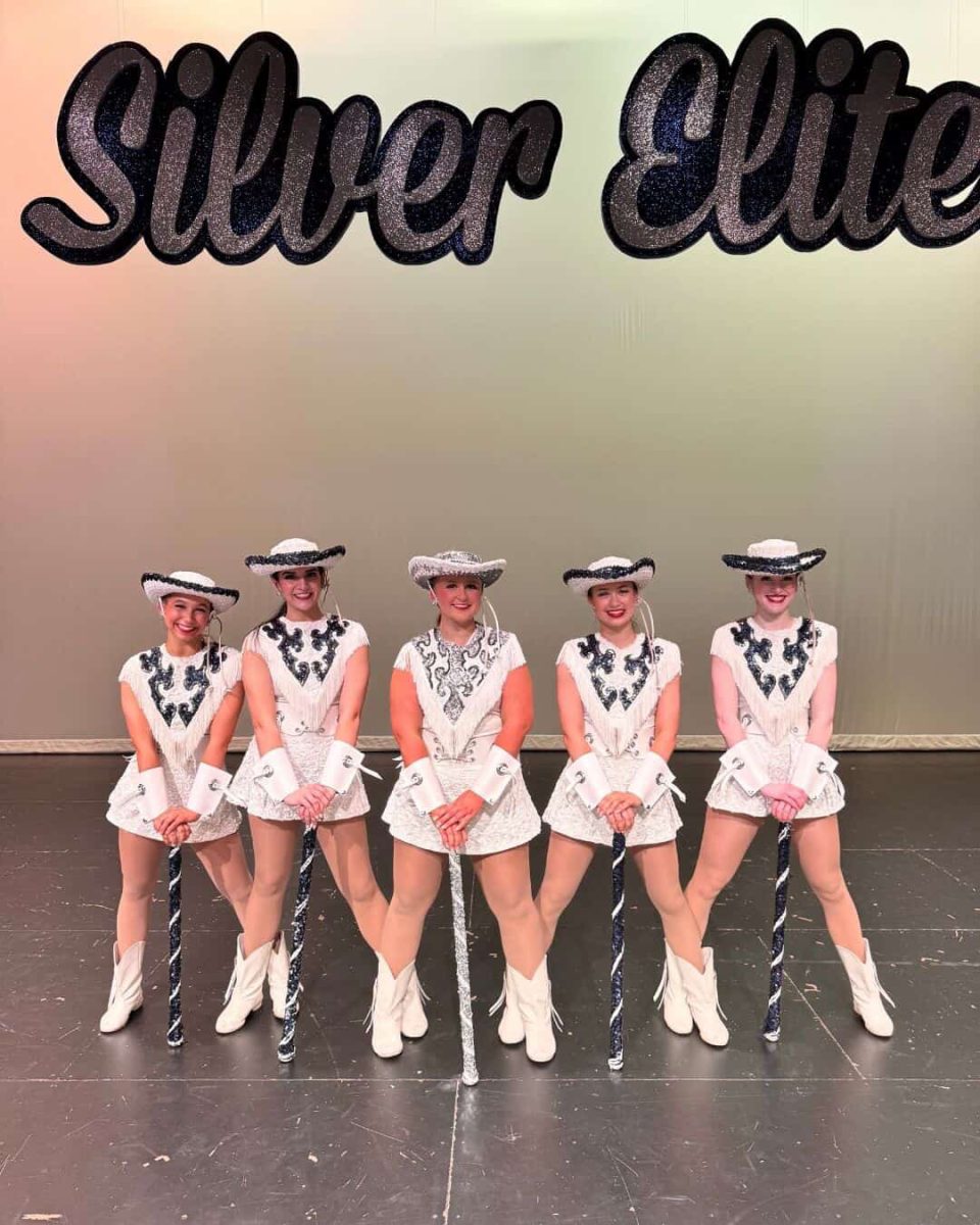 Senior Kaylee Mitchell shines at Spring Show, standing proudly in the center with her fellow Silver Elite officers