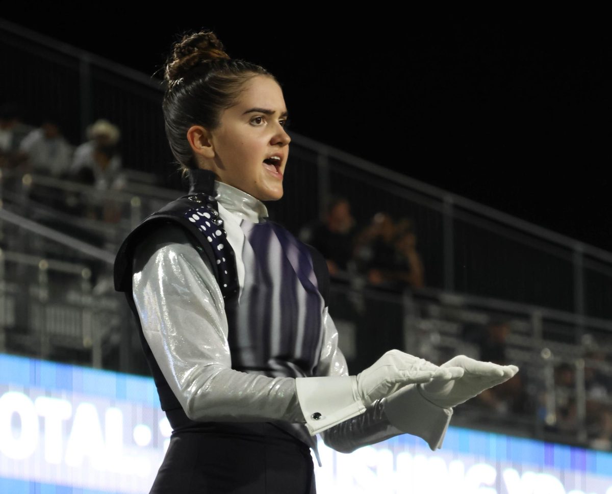 Junior Gabby Guydosh leads the band at Children's Health Stadium during halftime. 