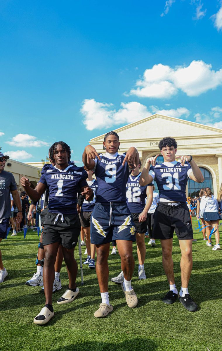 Varsity football strikes a pose during Navy Out pep rally.