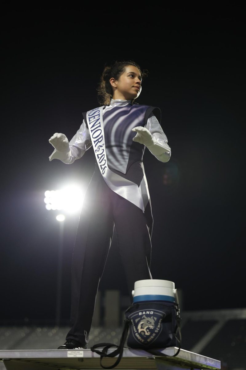 Hands poised, Senior Jeel Soni conducts the band through the fight song.