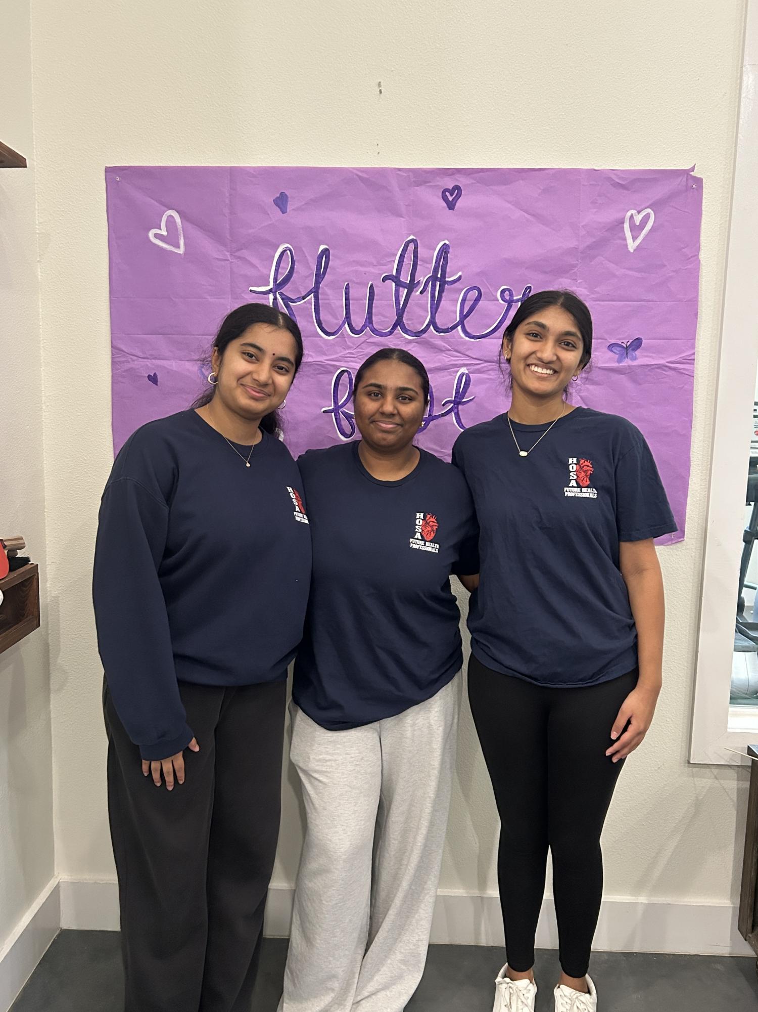 Sahasra Rudraraju, Dhanvi Kodali and Saanvi Yepuru pose in front of Flutter Fest banner promoting their event.
Photo courtesy of Sahasra Rudraju