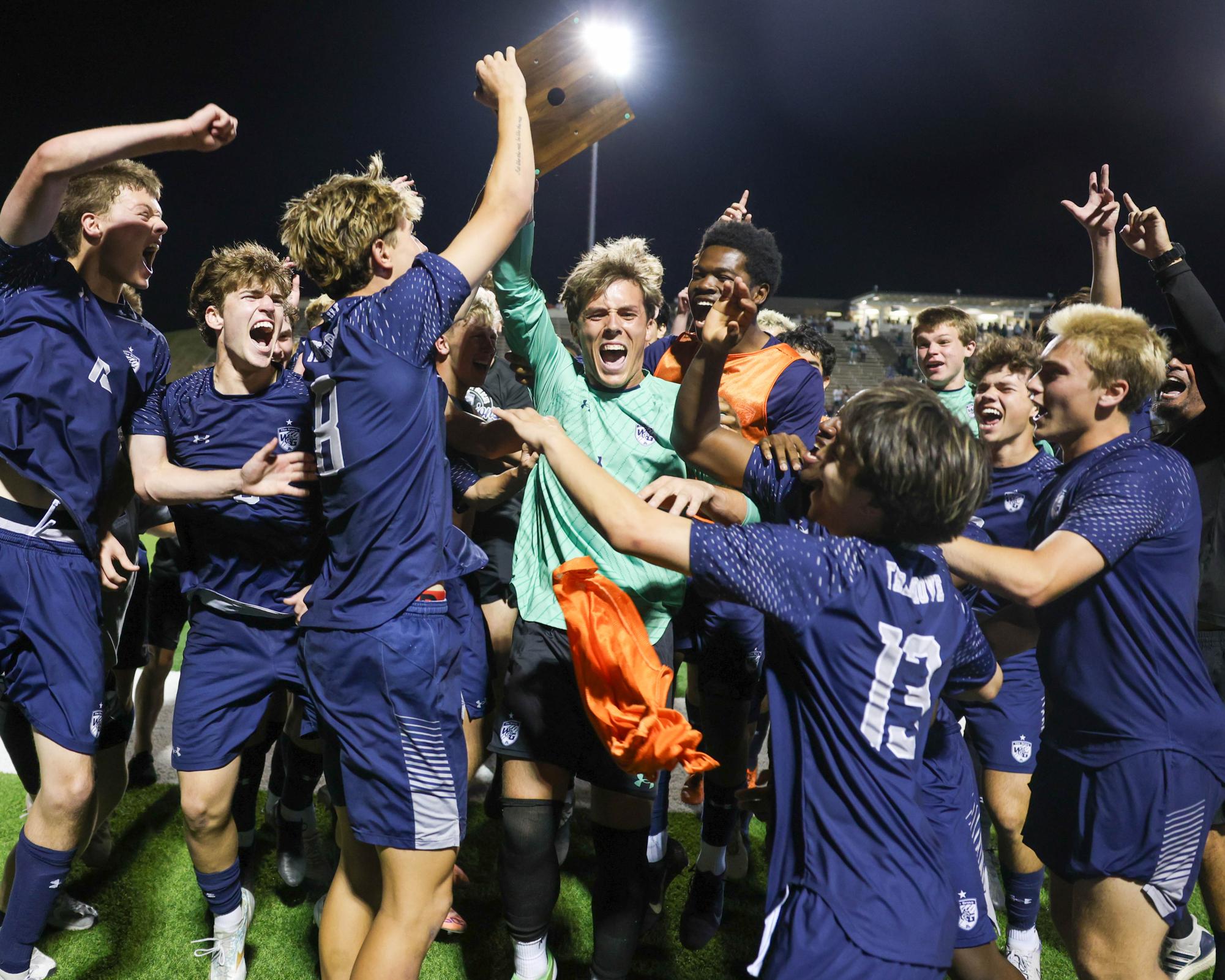 Goalie Quin Shelton holds regional championship trophy.