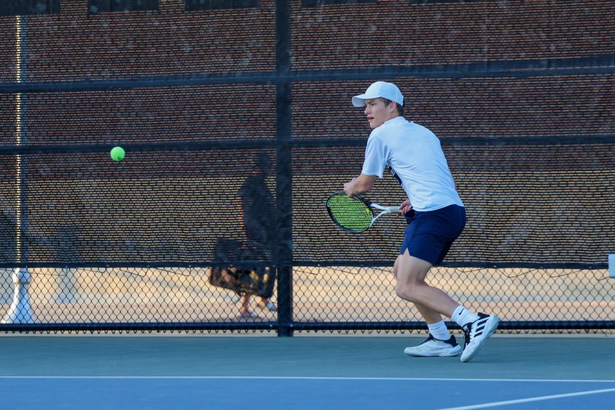 Eyes on the ball, junior Everett Camp keeps his focus as he swings his racket. During this tournament, Camp played with doubles partner senior Kenna Thornton and both went on to win this match.