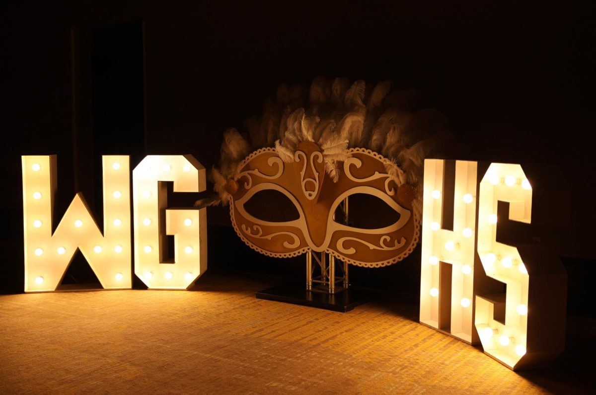 The decorations show the theme, the Gilded Masquerade. This sign has the letters WG on one side of the large masquerade mask and HS on the other.